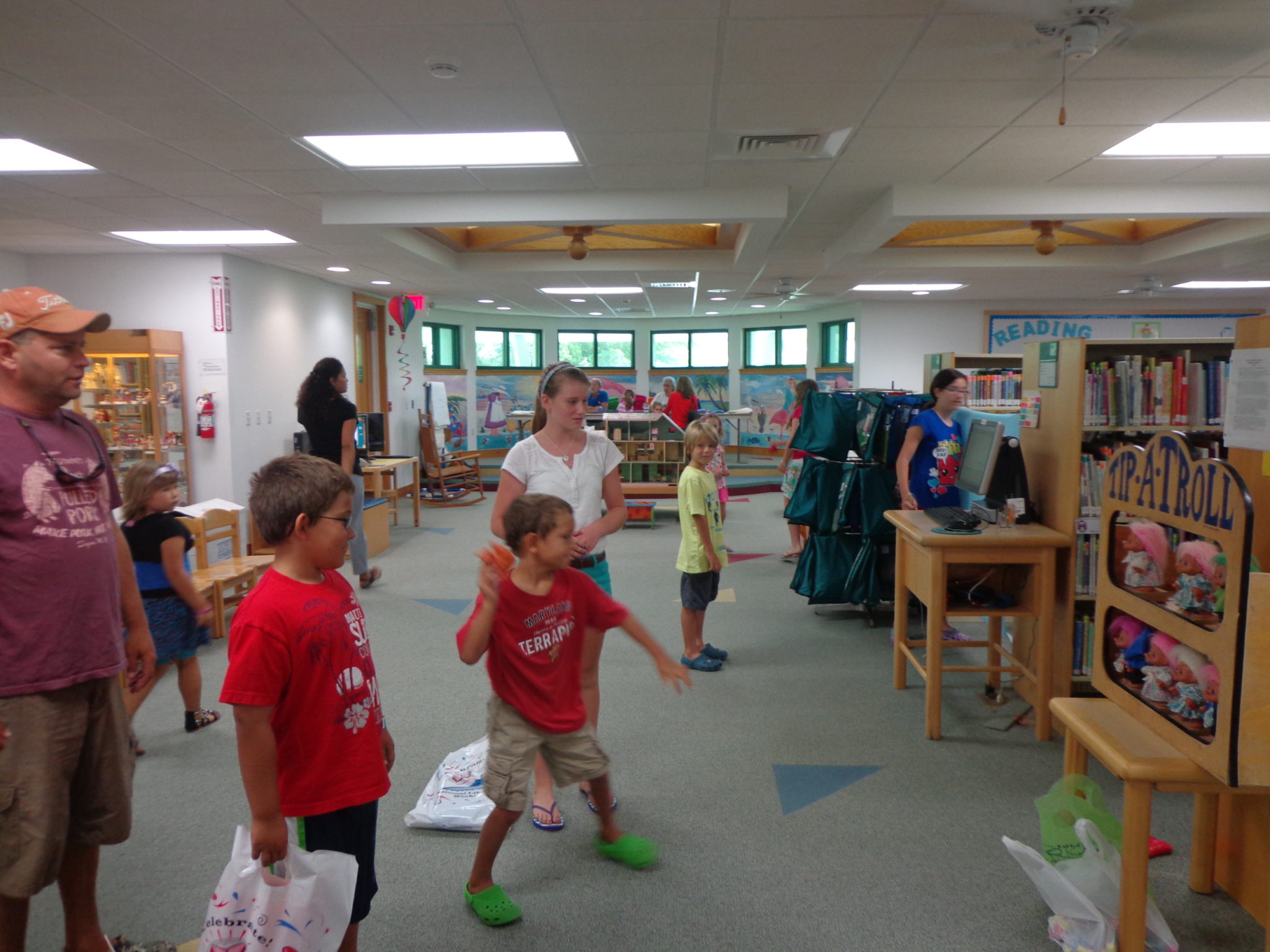 Boy throws ball as others watch in Children's area at Sanibel Public Library